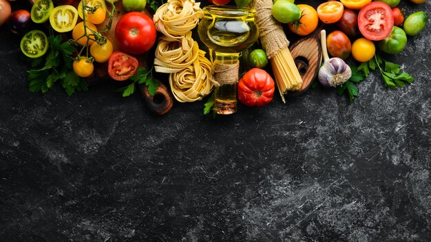 Massa seca tomates verdes óleo e ingredientes cozinha tradicional italiana legumes frescos vista superior espaço livre para o seu texto