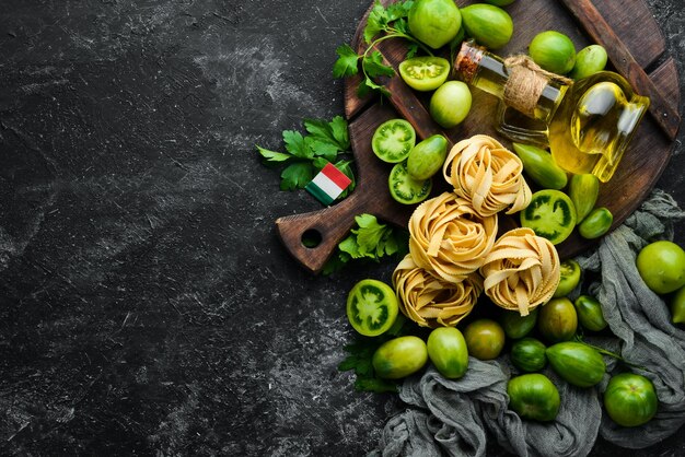 Massa seca tomates verdes óleo e ingredientes Cozinha tradicional italiana Legumes frescos Vista superior Espaço livre para o seu texto