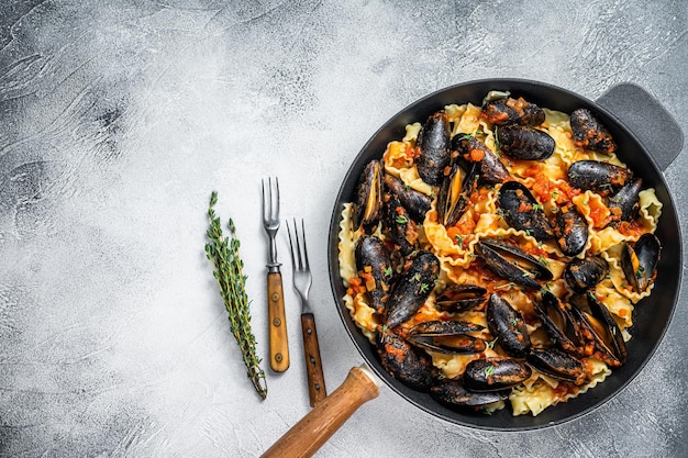Massa tradicional italiana de frutos do mar com mexilhões, espaguete e molho de tomate. Fundo branco. Vista do topo. Copie o espaço.
