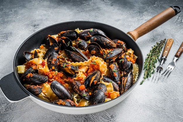 Massa tradicional italiana de frutos do mar com mexilhões, espaguete e molho de tomate. Fundo branco. Vista do topo.