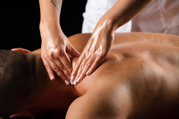 Massage für den Physiotherapeuten des Mannes, der die männliche Schulter massiert