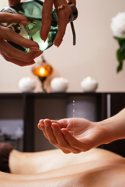 Massage-Öl. Rückenmassage mit Öl. Das Konzept der Spa-Behandlungen und Körperpflege. Foto in hoher Qualität
