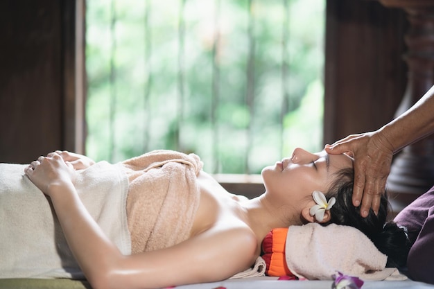 Massage und Spa entspannende Behandlung des Bürosyndroms im traditionellen thailändischen Massagestil Asain-Masseurin, die eine Massage durchführt, behandelt Rückenschmerzen, Armschmerzen und Stress für Bürofrauen, die von der Arbeit müde sind