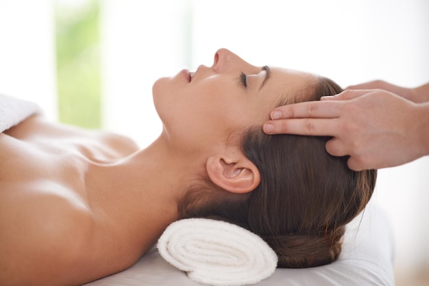 Foto massagem da cabeça e das mãos na mulher no spa para relaxar na mesa para tratamento de cuidados com a pele ou facial pessoa de beleza e menina calma em salão de luxo ou resort em férias ou férias com saúde e bem-estar