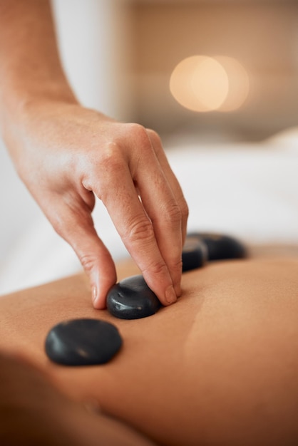 Massagem de terapia com pedras quentes e relaxe em um spa resort de luxo para terapia de relaxamento de tratamento de bem-estar com mãos e cura orgânica Mulher em um salão de beleza cuidados naturais com a pele e energia para a saúde do corpo