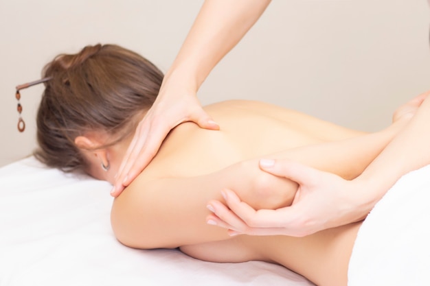 Massagem e cuidados com o corpo. Spa mulher massagem corporal com tratamento de mãos. Alongamento dos músculos das costas.