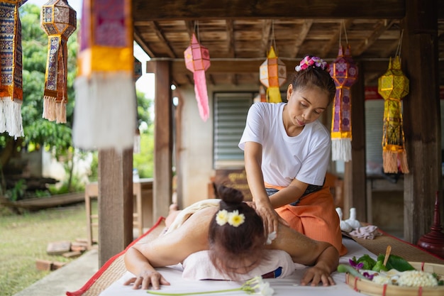 Foto massagem e spa tratamento relaxante da síndrome do escritório estilo tradicional de massagem tailandesa asain massagista feminina fazendo massagem e esfrega a pele tratar dor nas costas dor no braço e estresse para uma boa pele e saúde