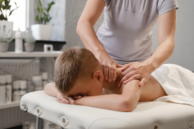 Massagem infantil na clínica Menino fazendo fisioterapia