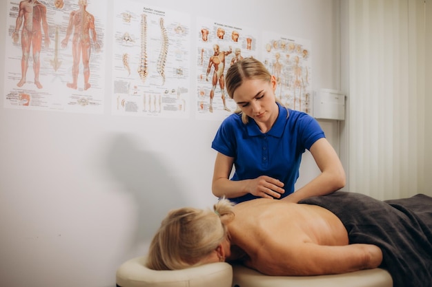 massagem médica para uma mulher aposentada num centro de reabilitação