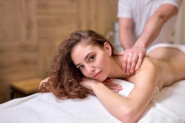 Massagem nas costas para jovem em um salão de spa moderno.