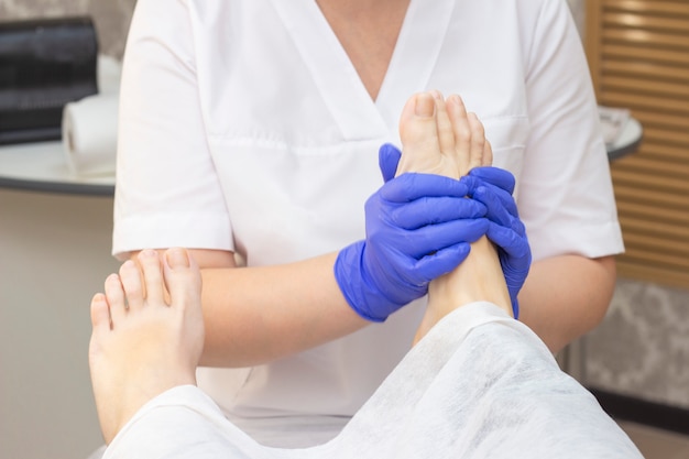 Massagem nos pés no salão spa, closeup. massagem nos pés relaxar cuidados com a pele. Pedicure terapêutico.