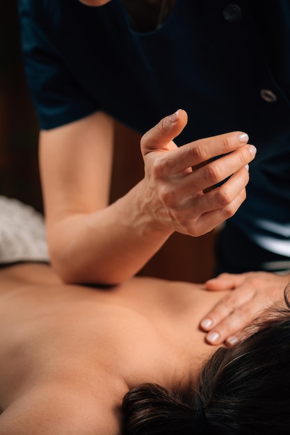 Massagem Terapêutica de Tecidos Profundos. Terapeuta massageando as costas da mulher, usando a pressão do cotovelo.