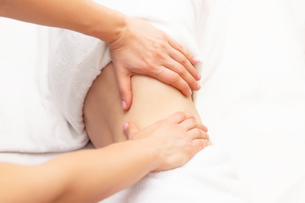 Massagetherapeut, der einen Frauenmagen massiert. Massage und Körperpflege. Badekurortkörpermassagefrau übergibt Behandlung.