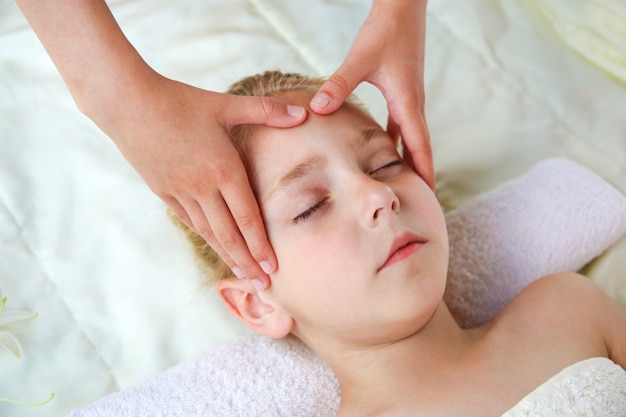 Massagista fazendo massagem de rosto para criança.