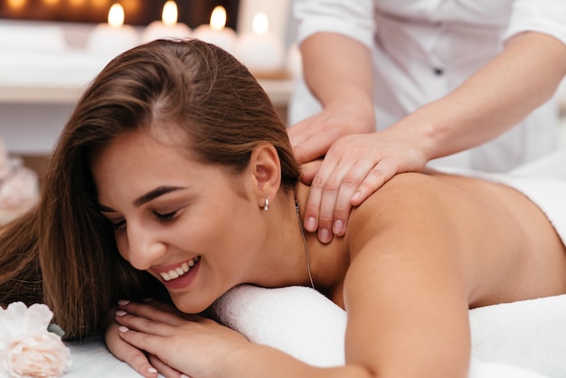 Massagista fazendo massagem na cabeça de uma mulher adulta no salão spa.