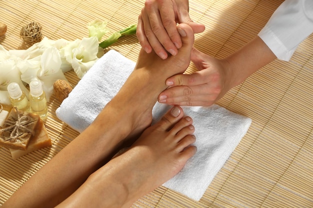 Foto massagista fazendo massagem nos pés no salão spa