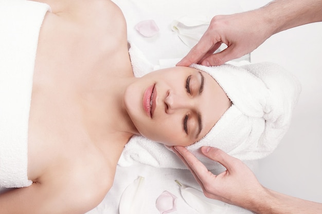 Massagista profissional fazendo massagem de rosto feminino