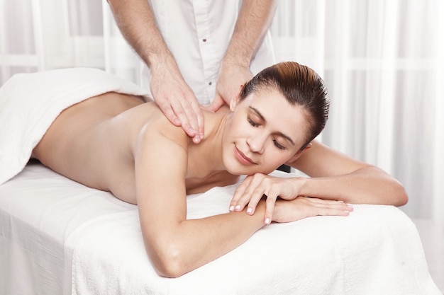 Massagista profissional fazendo massagem nas costas femininas