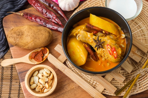 Massaman Curry com frango e ervas tailandesas com textura de fundo de madeira