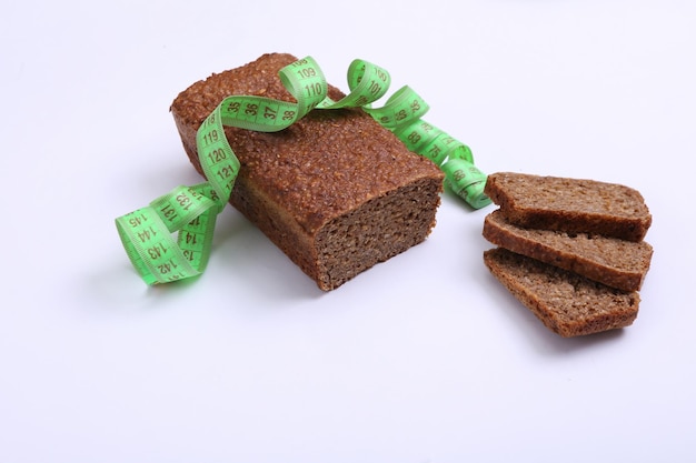 Maßband und Ernährung Roggenvollkornbrot auf weißem Hintergrund Diätkonzept zur Gewichtsabnahme