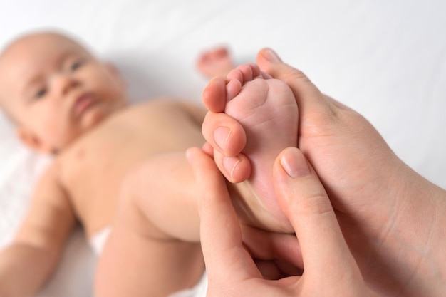 Masseur, der dem Baby Fußmassage gibt. Selektiver Fokus