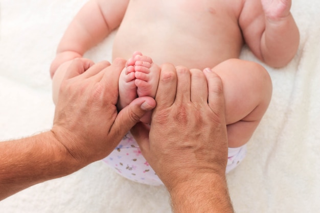 Masseur, der Massage für kleines Baby des Fußes tut