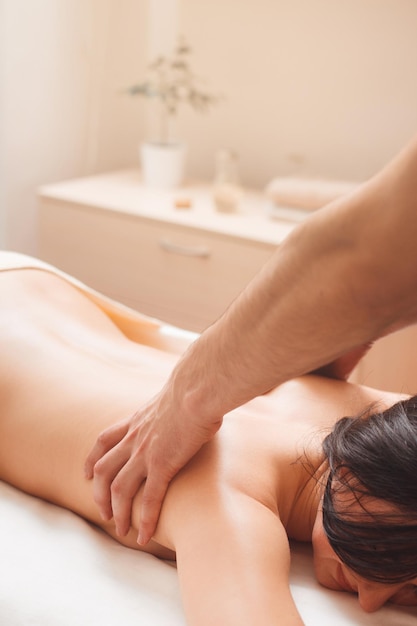 Masseur massiert Frau im Salon Junges Mädchen, das sich im Spa entspannt Beauty Health Rest Body Concept