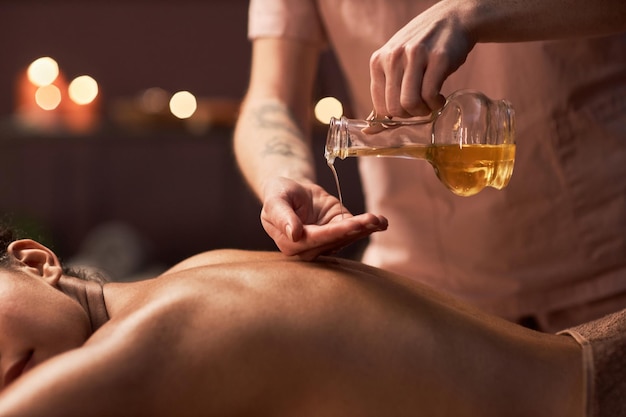 Masseurin trägt Öl auf dem Rücken auf
