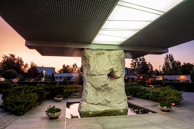 Massive Steinsäule, die das Verandadach des Landsitzes am Sommerabend trägt