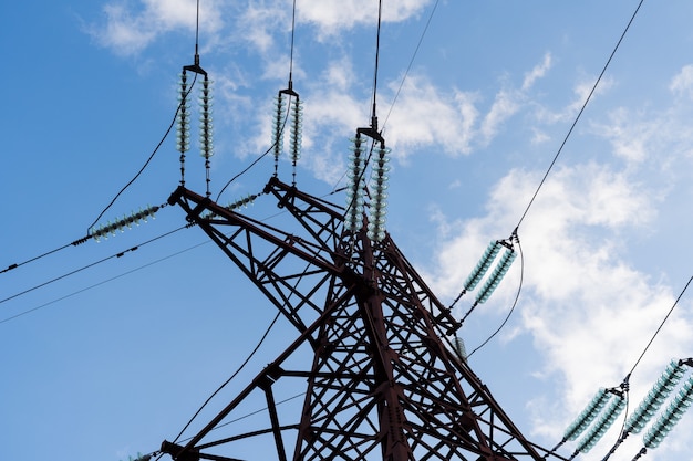 Mast- und Übertragungsstromleitung sehen unten an. Blauer Himmel