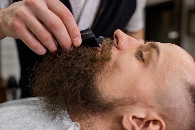 Master Barber hace peinados y peinados Concept Barbershop Estilo de barba y estilo de corte de barba negra Tan moderno y elegante Concepto de publicidad y barbería