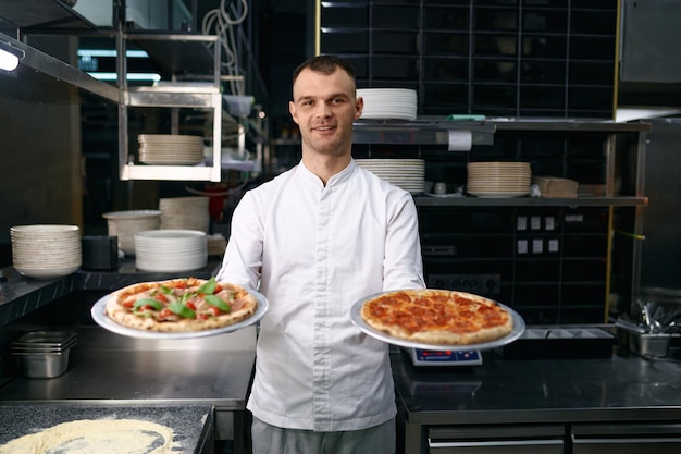 Master chef apresentando dois tipos de pizza recém cozida. Escola de culinária, restaurante de fast food e conceito de gastronomia