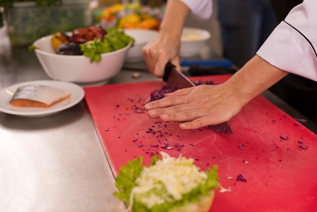 master chef cortando salada para hambúrguer na cozinha rastaurant