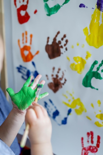 Foto master class infantil no desenho, a criança faz uma marca de mão com tinta