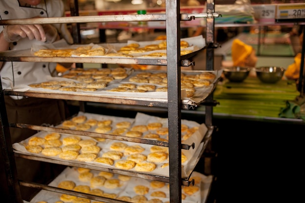 Master class para crianças em cozinhar biscoitos. o cozinheiro coloca assadeiras com biscoitos no forno