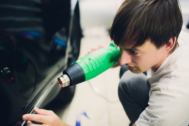 Master instala película de tinte para automóvil con secador de pelo. Concept concept car