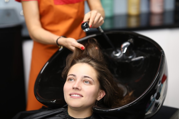 Master lava su cabello en el fregadero para el cliente en la peluquería