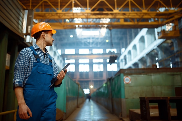 Master observa el trabajo del operador de la grúa en la fábrica de metal. Industria metalmecánica, fabricación industrial de producción de acero