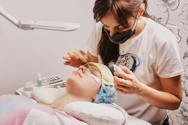 Foto master wimpernverlängerung bei der arbeit, klebstoff auftragen, heimarbeitsplatz