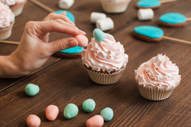 Masterclass de preparação de cupcakes decorados com creme branco na mesa de madeira