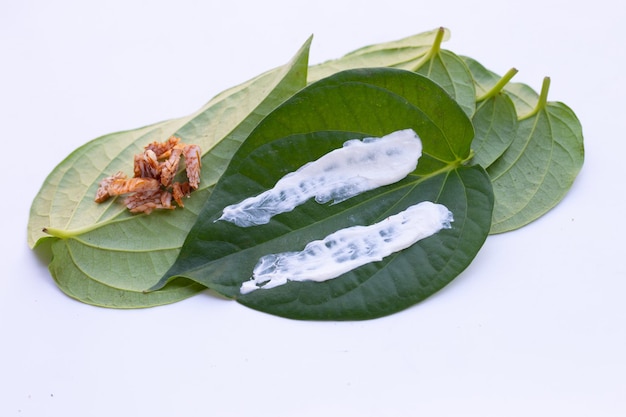 Masticar nuez de betel Nuez de betel con cal en polvo sobre hojas de betel