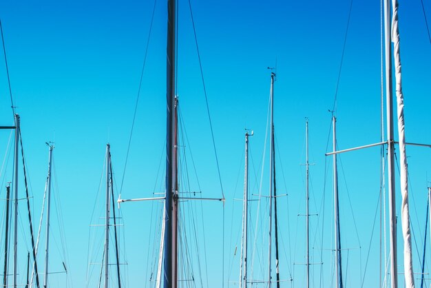 Los mástiles de los veleros en el puerto contra el cielo azul