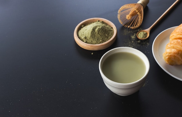 Matcha chá verde com leite na mesa preta