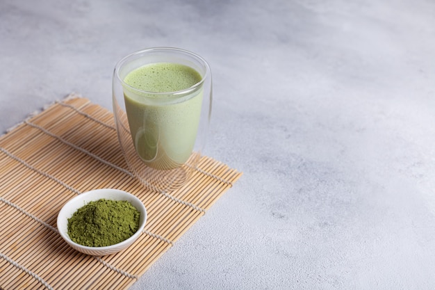 Matcha com leite em um copo em um fundo claro