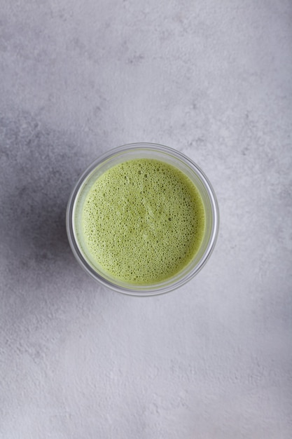 Matcha com leite em um copo em um fundo claro