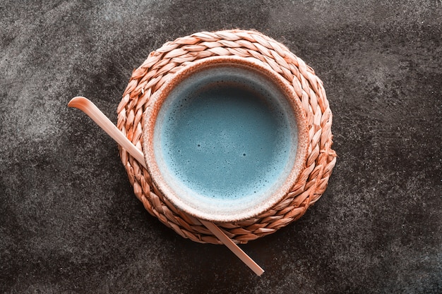 Foto matcha de chá azul em uma tigelas e chasen na superfície escura