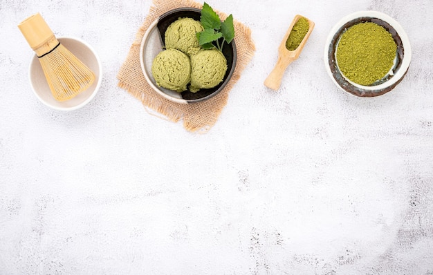 Matcha-Grüntee-Eis mit Waffelkegel auf weißem Stein.