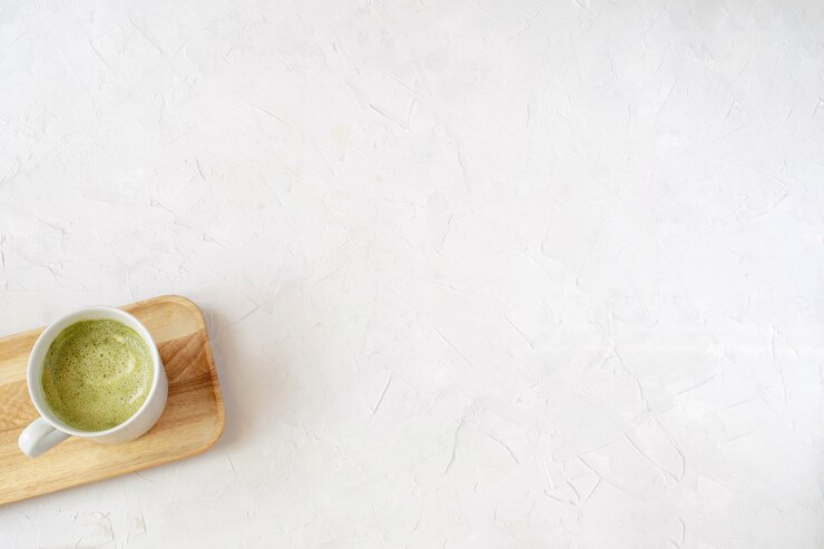 Matcha latte em copo branco na bandeja de madeira