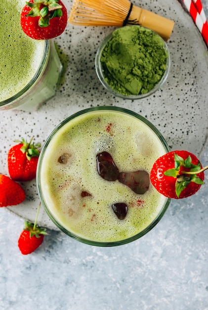 Matcha latte de fresa de verano con hielo en un vaso de vidrio