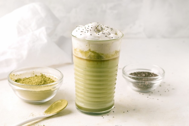 Foto matcha latte mit chiasamen auf hellem hintergrund neben den zutaten